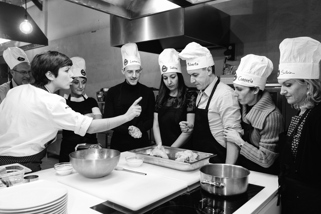 Fotografo Eventi Esclusivi Gilead FoodGeniusAcademy Una cuoca spiega dettagliatamente ai clienti come lavorare