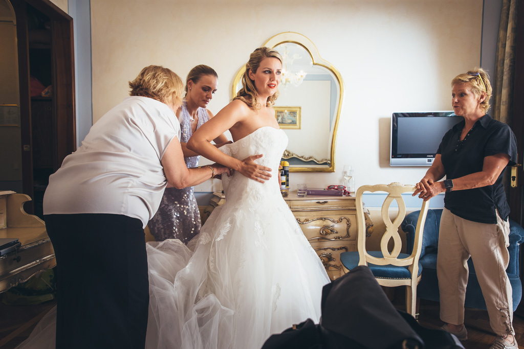 Fotografo Matrimonio Lago di Garda La damigelle sistemano il vestito della sposa