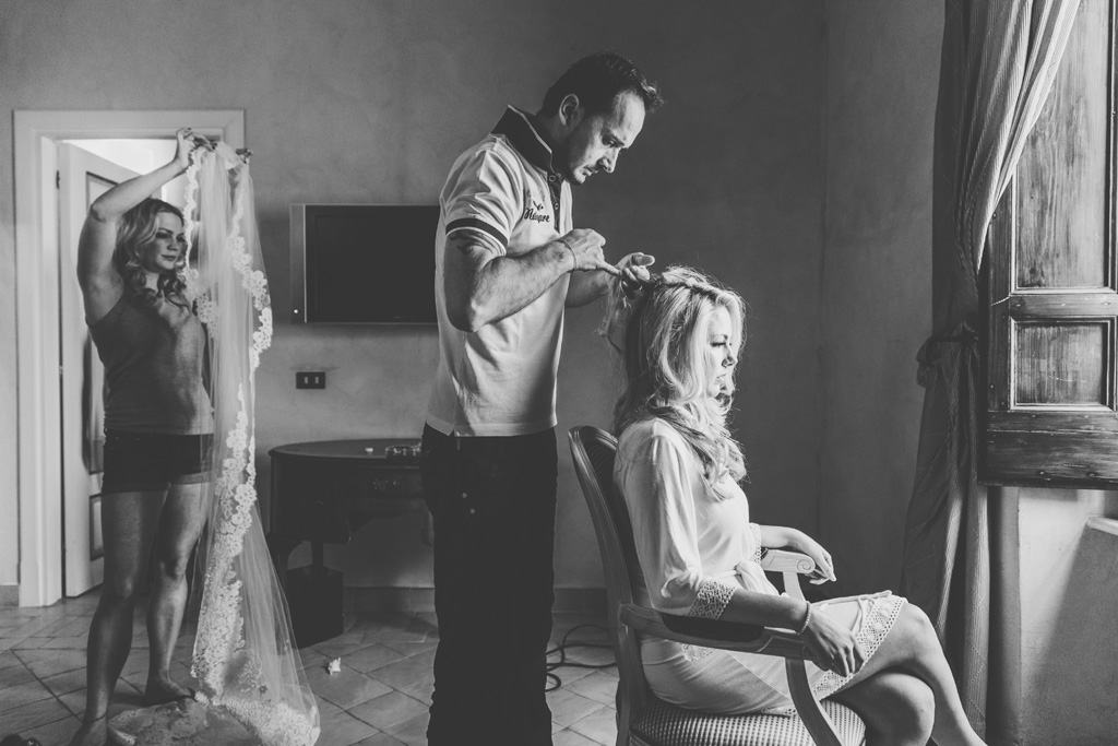 Fotografo Matrimonio Villa Del Cardinale Il parrucchiere sistema i capelli di Brittney durante la preparazione