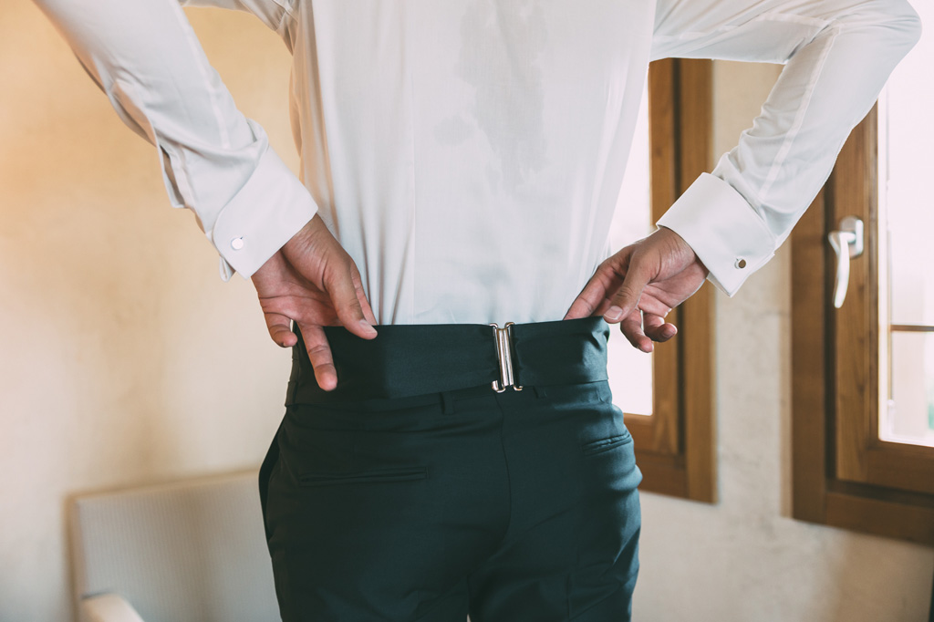Fotografo Matrimonio Lago di Garda Lo sposo aggiusta i pantaloni in preparazione della cerimonia