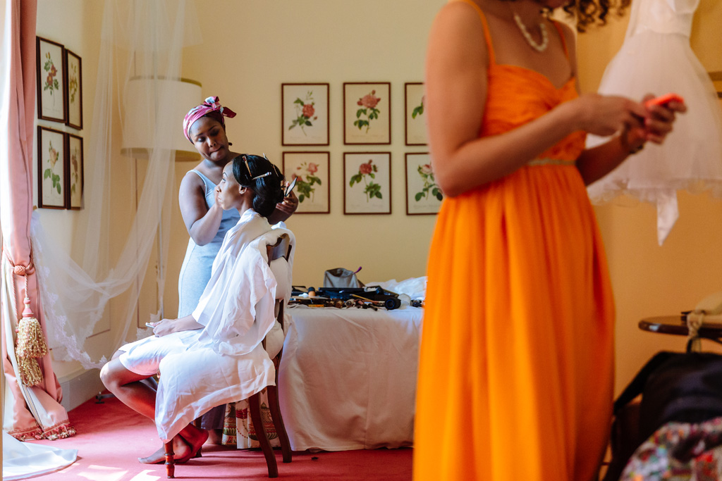 Fotografo Matrimonio Villa Erba La damigella acconcia la sposa in camera durante la preparazione