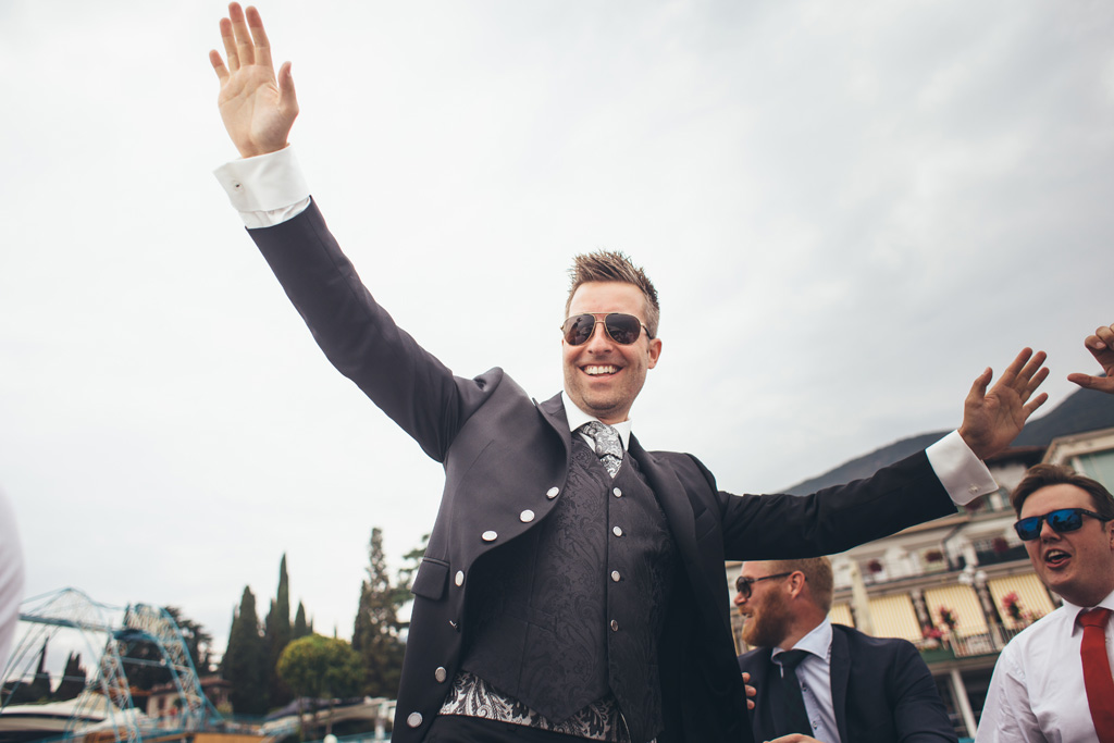 Fotografo Matrimonio Lago di Garda Lo sposo saluta alcuni ospiti prima di dirigersi in barca