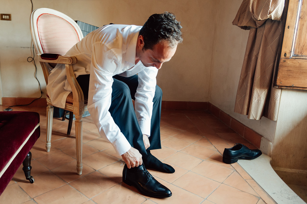 Fotografo Matrimonio Villa Del Cardinale Emmanuele sistema le scarpe in camera