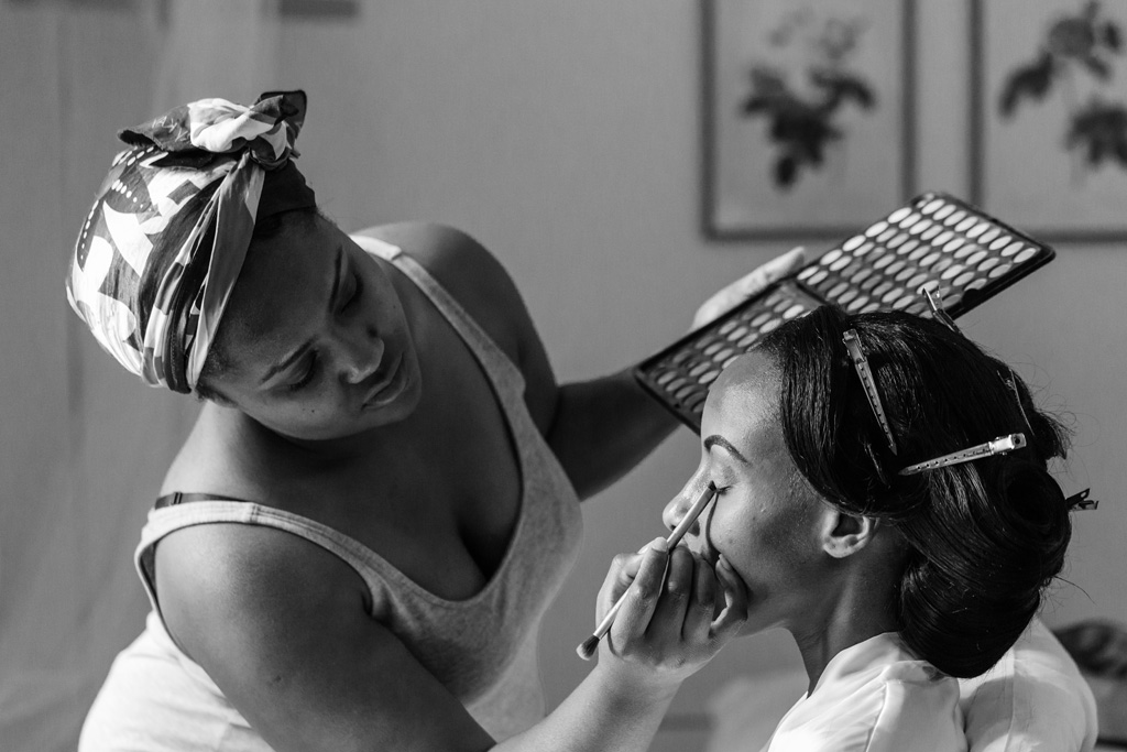 Fotografo Matrimonio Villa Erba Una damigella decora il viso della sposa