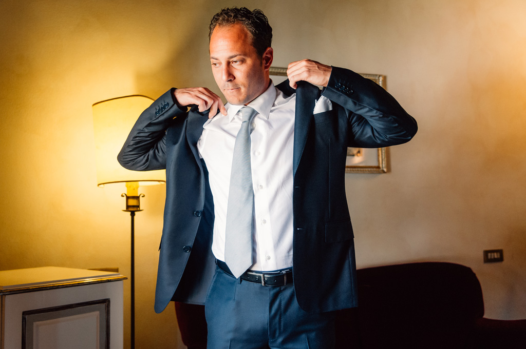 Fotografo Matrimonio Villa Del Cardinale Emmanuel aggiusta la giacca durante la preparazione