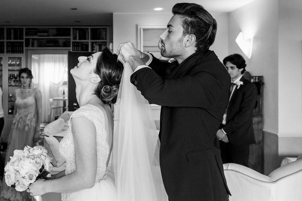 Fotografo Matrimonio Monza Un testimone si sistema il velo della sposa