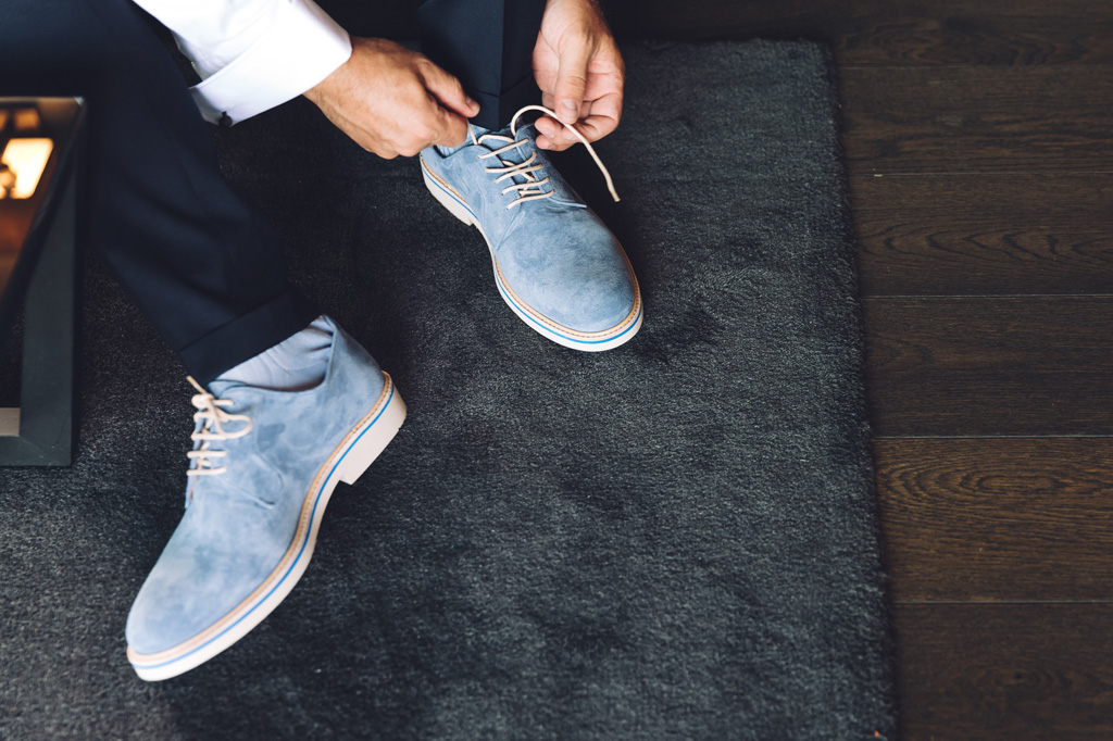 Fotografo Matrimonio Langhe LO sposo indossa le scarpe durante la preparazione