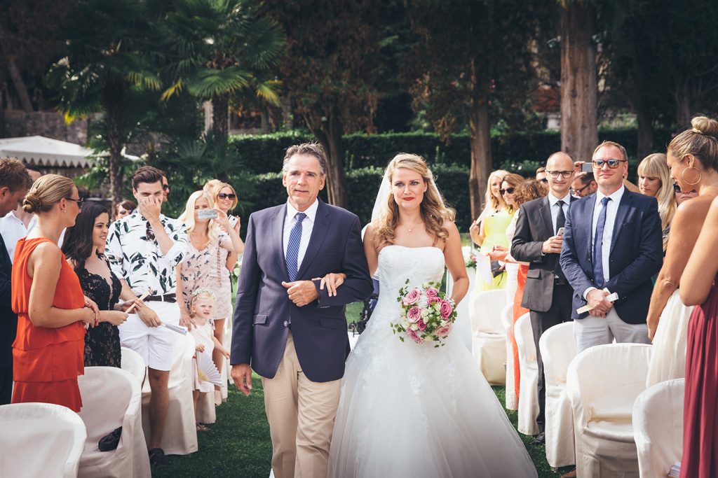 Fotografo Matrimonio Lago di Garda Il padre tiene a braccetto Katrin lungo il corridoio