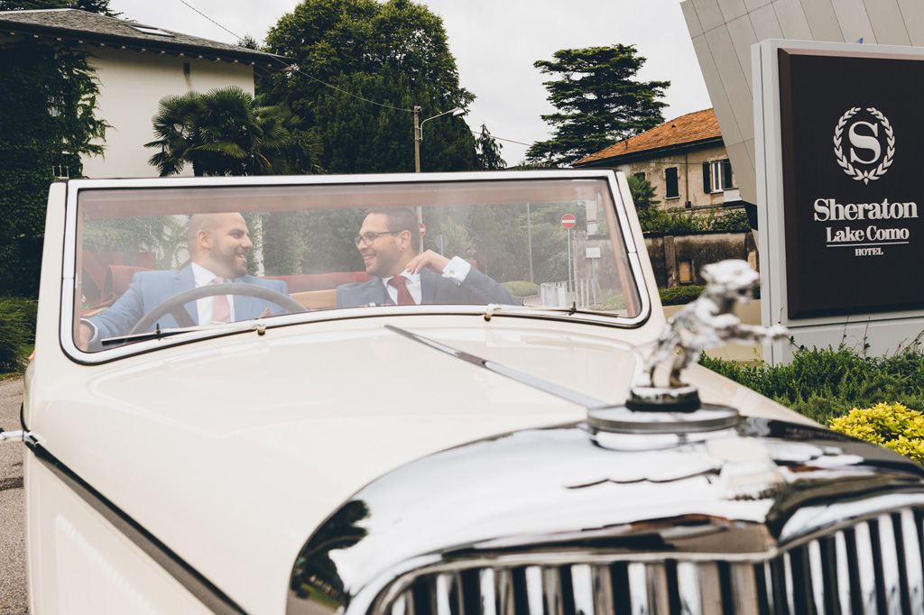 Fotografo Matrimonio Villa Erba Lo sposo scherza con un testimone durante il viaggio in macchina