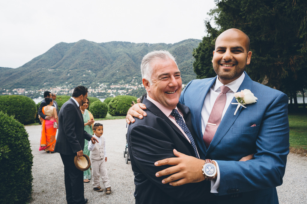 Fotografo Matrimonio Villa Erba Lo sposo abbraccia amici e parenti prima della cerimonia di matrimonio