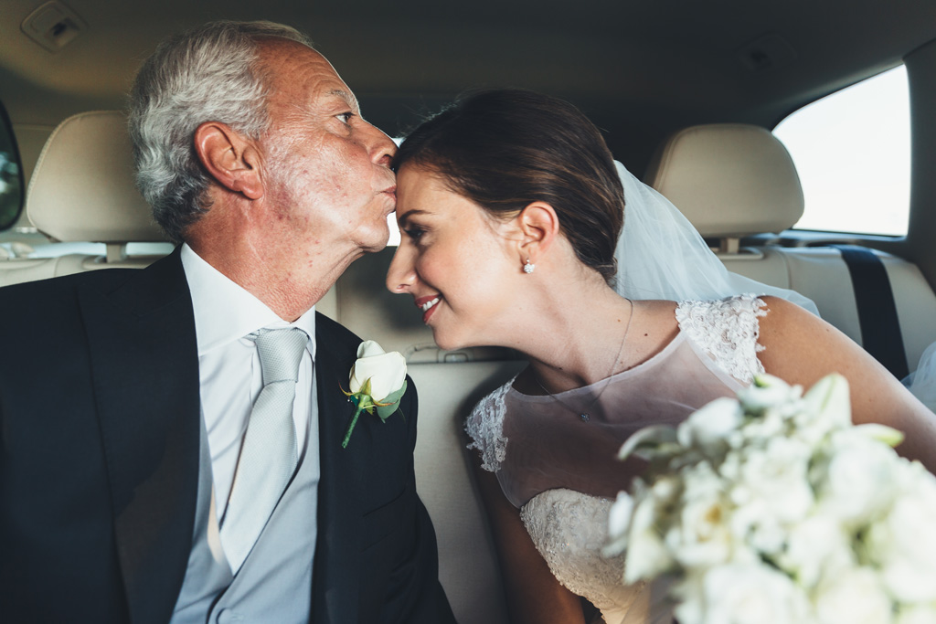 Fotografo Matrimonio Pavia Il padre bacia la fronte delle sposa in macchina