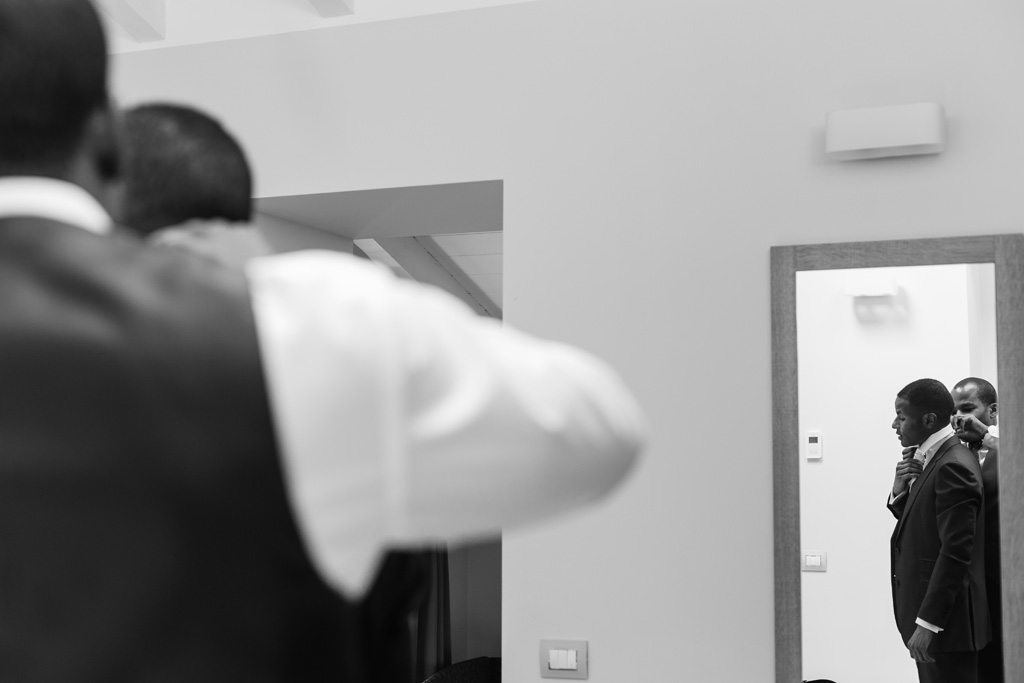 Fotografo Matrimonio Villa Erba Lo sposo è riflesso in uno specchio in uno scatto di Alessandro della Savia, fotografo Milano