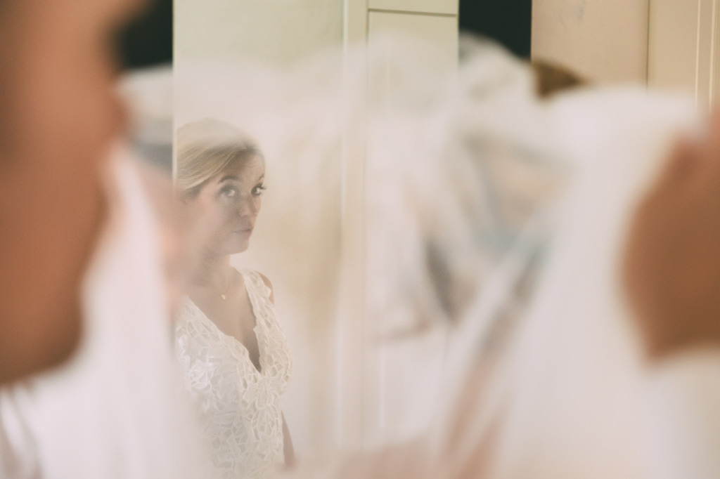 Fotografo Matrimonio Lago di Garda La sposa si specchia davanti allo specchio in un gioco di riflessi scattato da Alessandro Della Savia