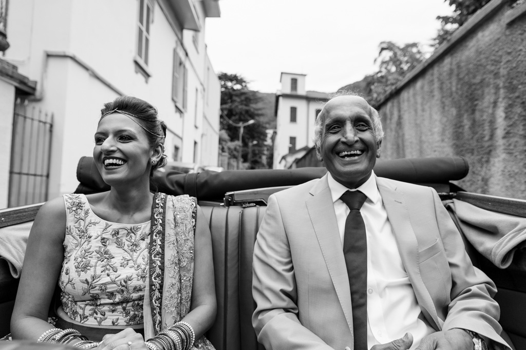 Fotografo Matrimonio Villa Erba La sposa ride allegramente in compagnia del padre durante il viaggio per il ricevimento