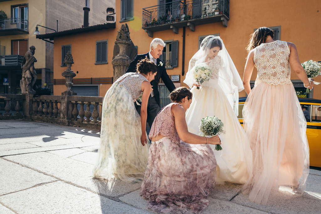 Fotografo Matrimonio Villa Caroli Zanchi La sposa sistema il vestito con le damigelle prima della cerimonia di matrimonio
