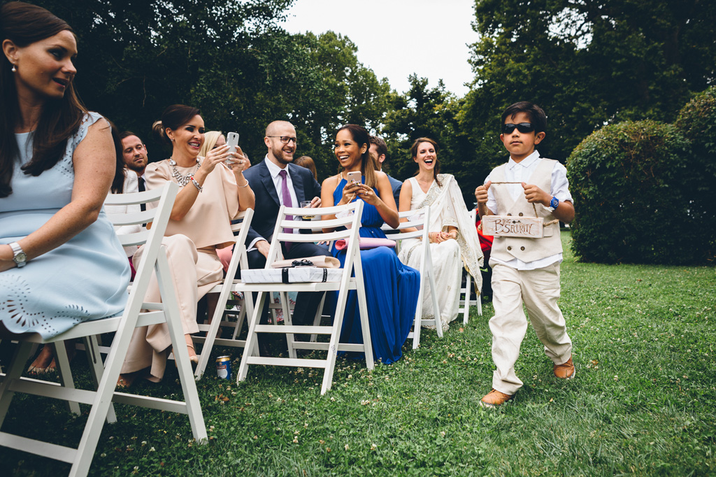 Fotografo Matrimonio Villa Erba Un bambino con gli occhiali da sole intrattiene gli ospiti