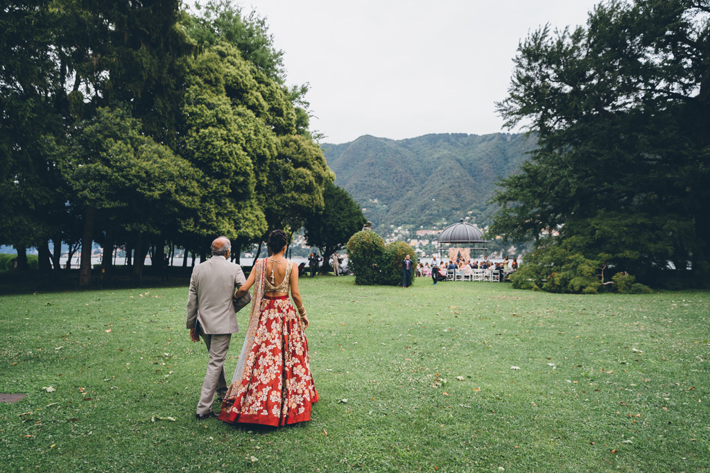 Fotografo Matrimonio Villa Erba Il padre cammina a braccetto la sposo in direzione del luogo della cerimonia