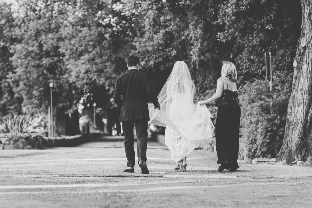 Fotografo Matrimonio Villa Del Cardinale La madre sostiene il vestito della sposa durante una passeggiata