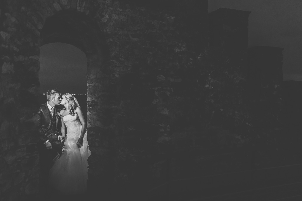 Fotografo Matrimonio Lago di Garda I due sposi si baciano in una atmosfera di un castello diroccato nei pressi del Lago di Garda