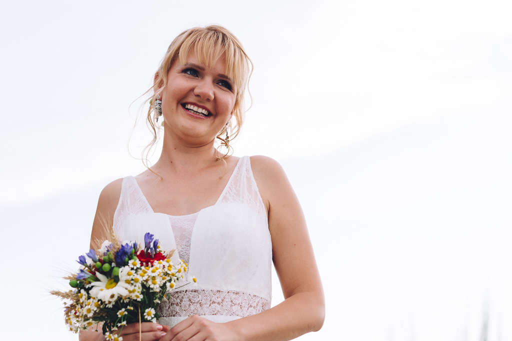 Fotografo Matrimonio Langhe La sposa sorride con il bouquet in mano ritratta da Alessandro Della Savia