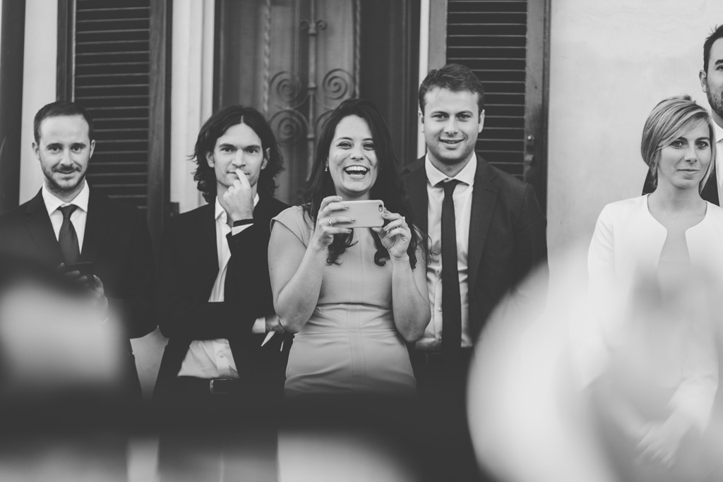 Fotografo Matrimonio Pavia Un'invitata ride mentre scatta una foto agli sposi