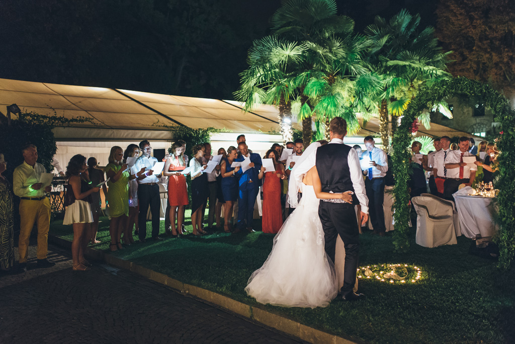 Fotografo Matrimonio Lago di Garda Martin abbraccia la sposa e gli ospiti si dilettano a scattare qualche immagine con il cellulare