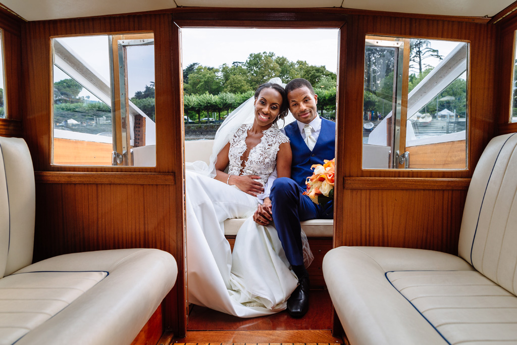 Fotografo Matrimonio Villa Erba I due sposi, Tony e Ayesha, sorridono raggianti in barca