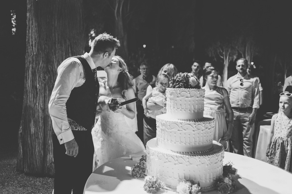 Fotografo Matrimonio Lago di Garda I due sposi, Martin e Kathrin, si baciano davanti alla torta