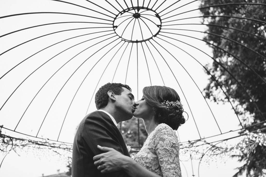 Fotografo Matrimonio Villa Caroli Zanchi I due sposi si baciano sotto il gazebo