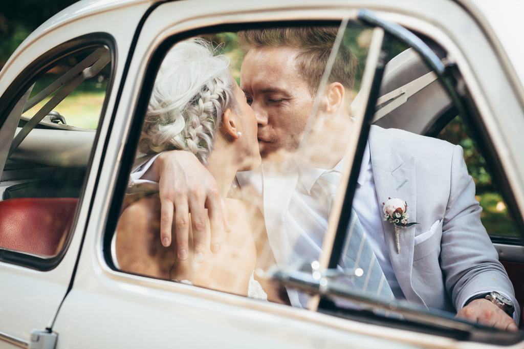 Fotografo Matrimonio Orvieto I due sposi si baciano in macchina ripresi dal finestrine