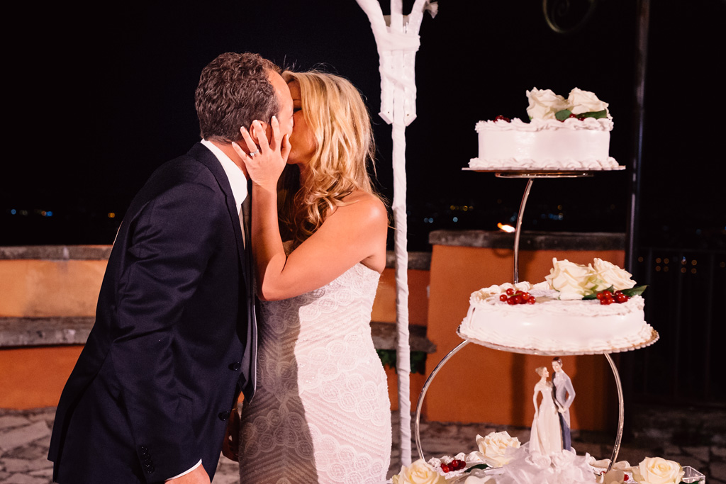 Fotografo Matrimonio Villa Del Cardinale Emmanuele e Brittney si baciano davanti alla torta nunziale