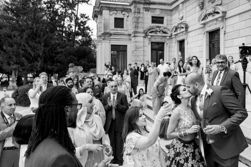 Fotografo Matrimonio Villa Erba La folla acclama gli sposi mentre si baciano