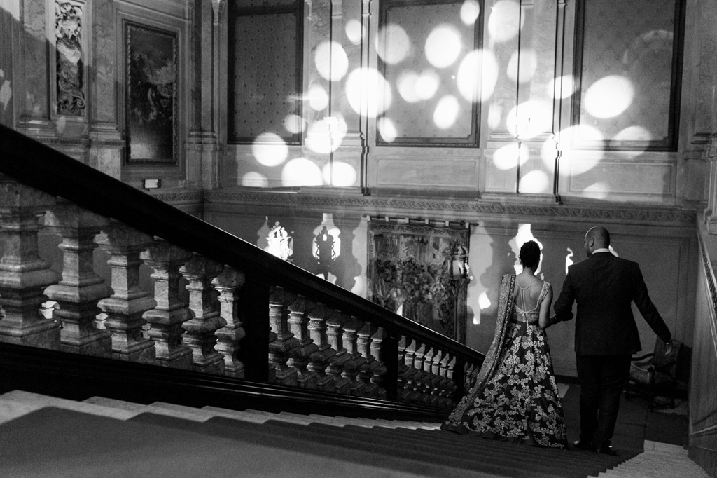 Fotografo Matrimonio Villa Erba Gli sposi scendono le scale durante uno spettacolo di luci
