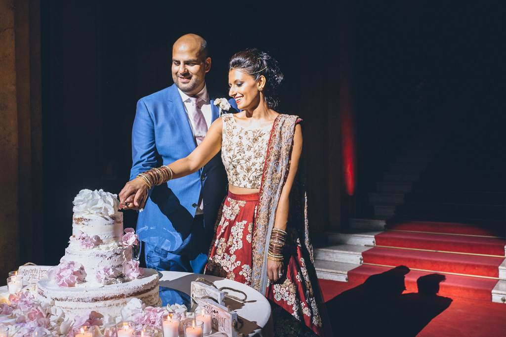 Fotografo Matrimonio Villa Erba Gli sposi tagliano la torta nunziale sotto i riflettori