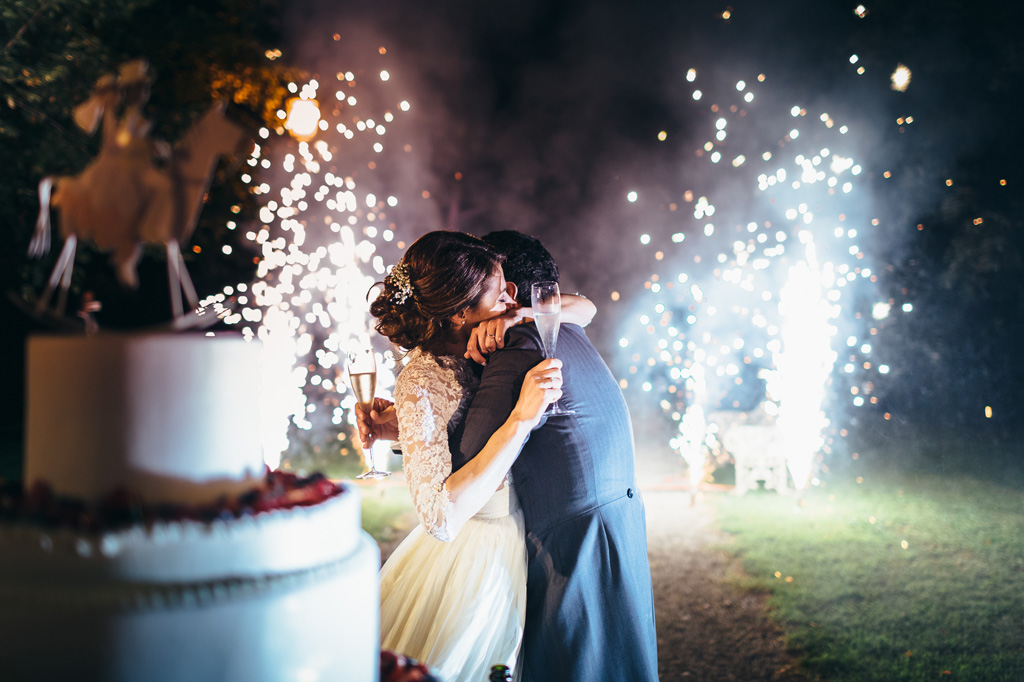 Fotografo Matrimonio Villa Caroli Zanchi I due sposi, Riccardo e Beatrice, si abbracciano nella magia dei fuochi d'artificio