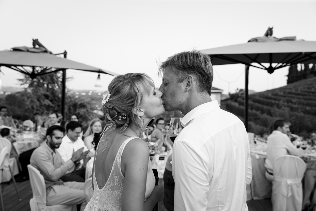 Fotografo Matrimonio Langhe I due sposi si baciano davanti agli invitati