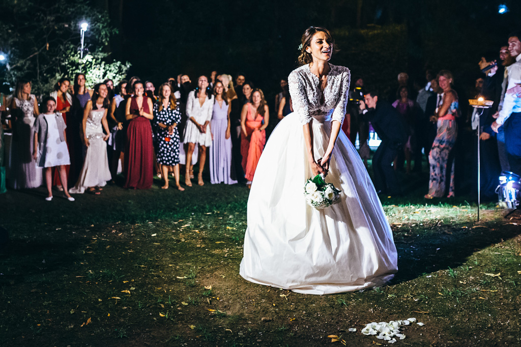 Fotografo Matrimonio Villa Caroli Zanchi Beatrice lancia il bouquet tra le invitate in uno scatto di Alessandro Della Savia