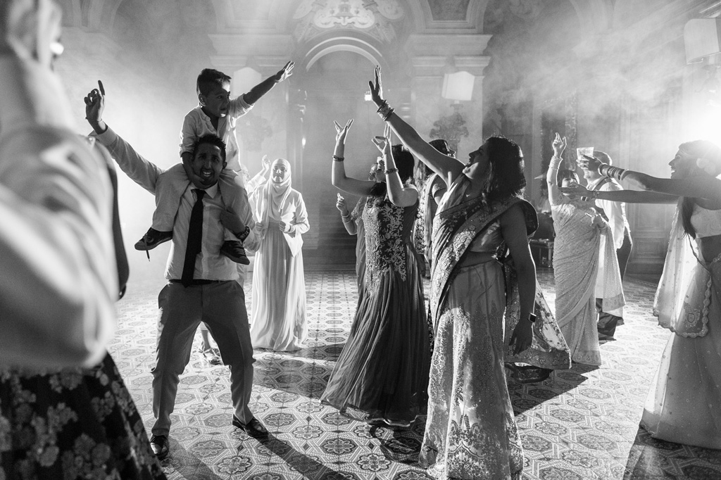 Fotografo Matrimonio Villa Erba Un invitato danzo con un bambino sulle spalle