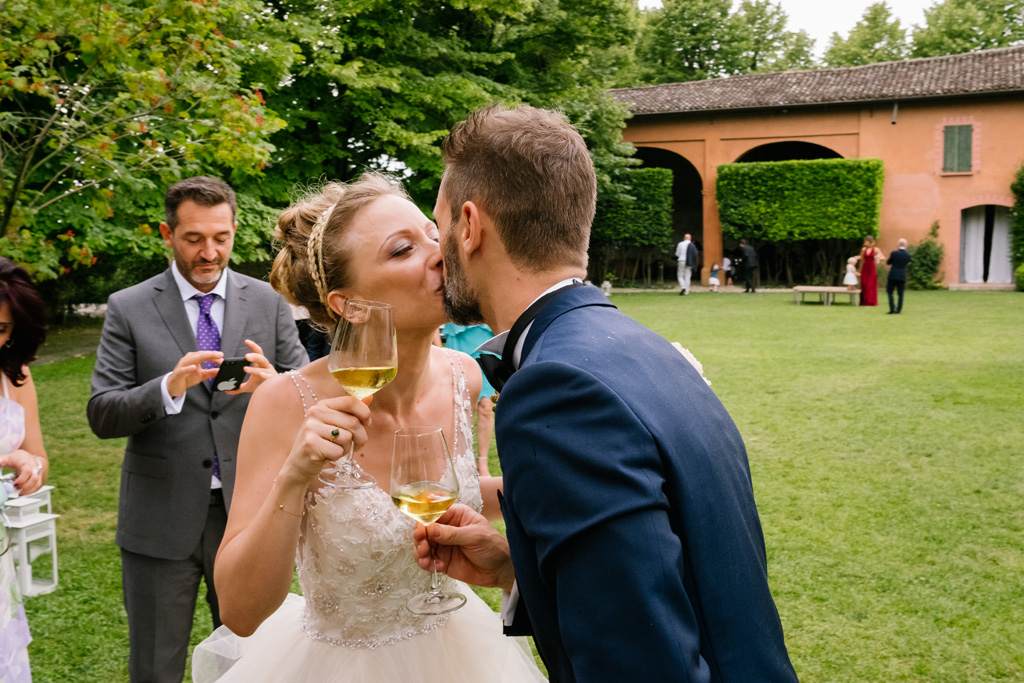 Fotografo Matrimonio Convento Dell'Annunciata Medole Gli sposi si baciano mentre brindano alla loro unione