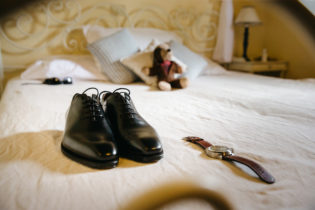 Fotografo Matrimonio Basilica San Galgano Toscana Scarpe e orologio dello sposo sul letto