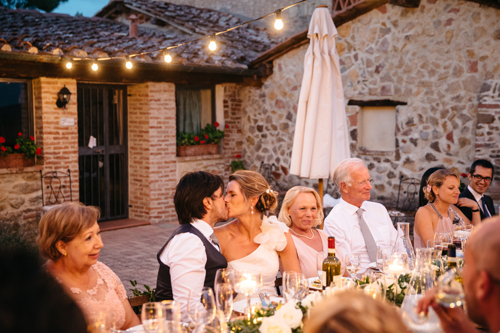 Fotografo Matrimonio Basilica San Galgano Toscana Gli sposi si baciano durante la cena