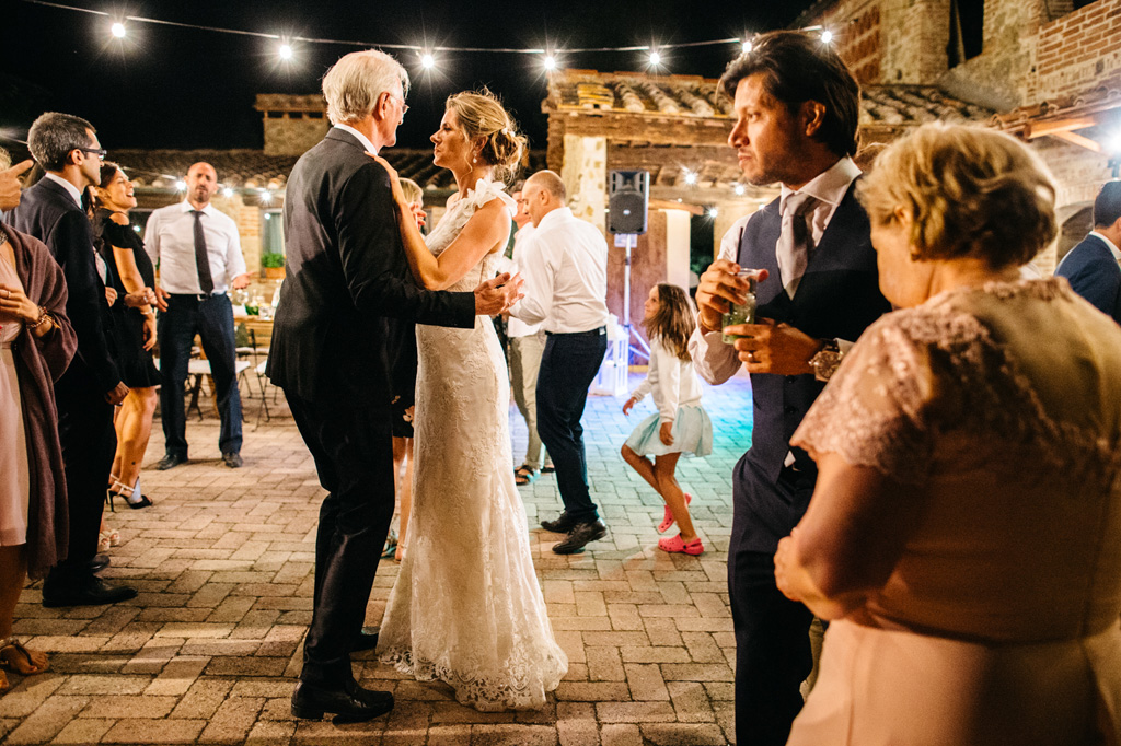 Fotografo Matrimonio Basilica San Galgano Toscana La sposa balla con il padre mentre lo sposo sta insieme alla mamma