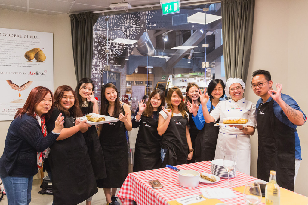 Fotografo Evento Aziendale Milano Eataly Boeucc Alessandro Della Savia, fotografo di eventi aziendali, ritrae i componenti dell'azienda Tokio Marine Holdings con la torta di mele pronta da mangiare