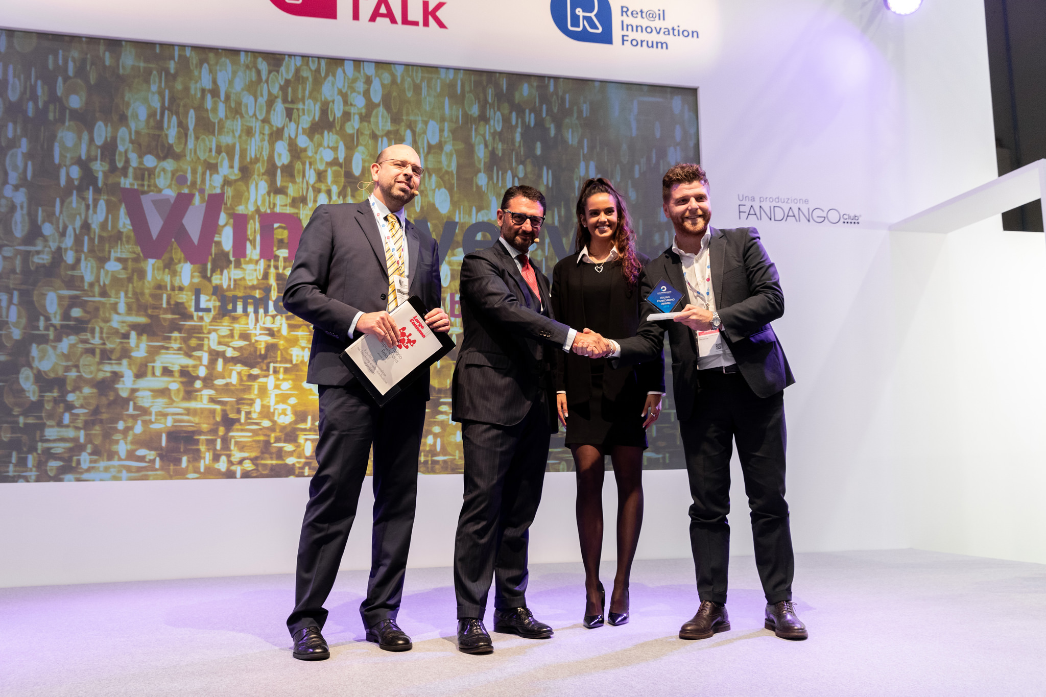 Fotografo Eventi Esclusivi Aziendali Fiera Milano Assofranchisin I vincitori stringono la mano ai presentatori dell'evento presso Fireramilanocity