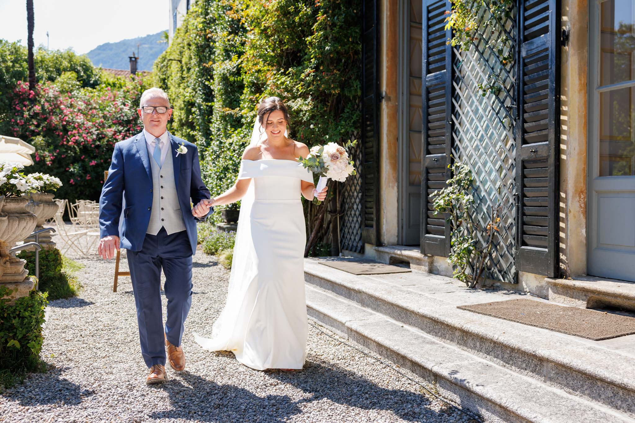 Destination Wedding Photographer Como Una sposa e suo padre che camminano verso la cerimonia del matrimonio