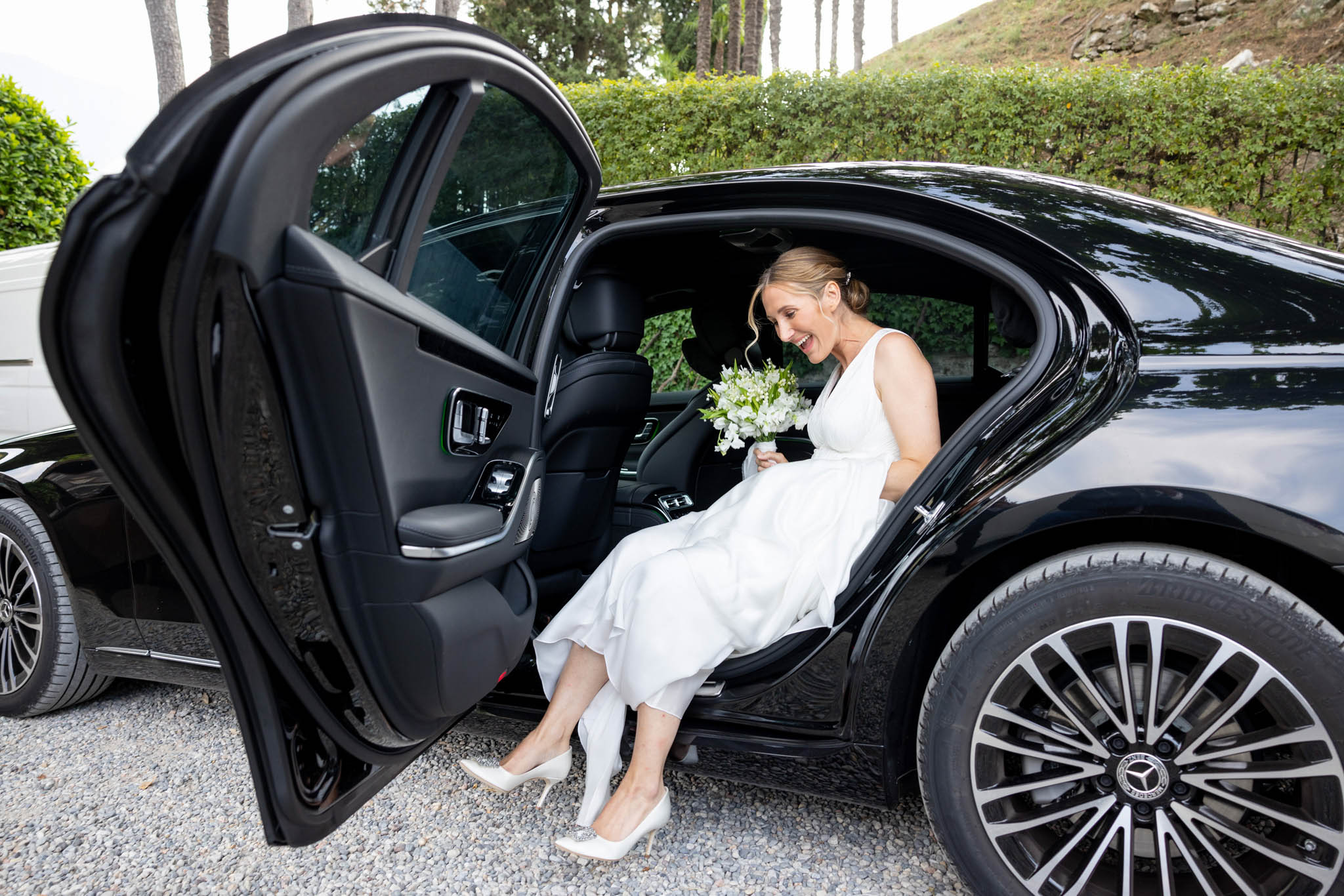 Destination Wedding Photographer Lake Como Una sposa che scende dall'auto per arrivare al suo matrimonio
