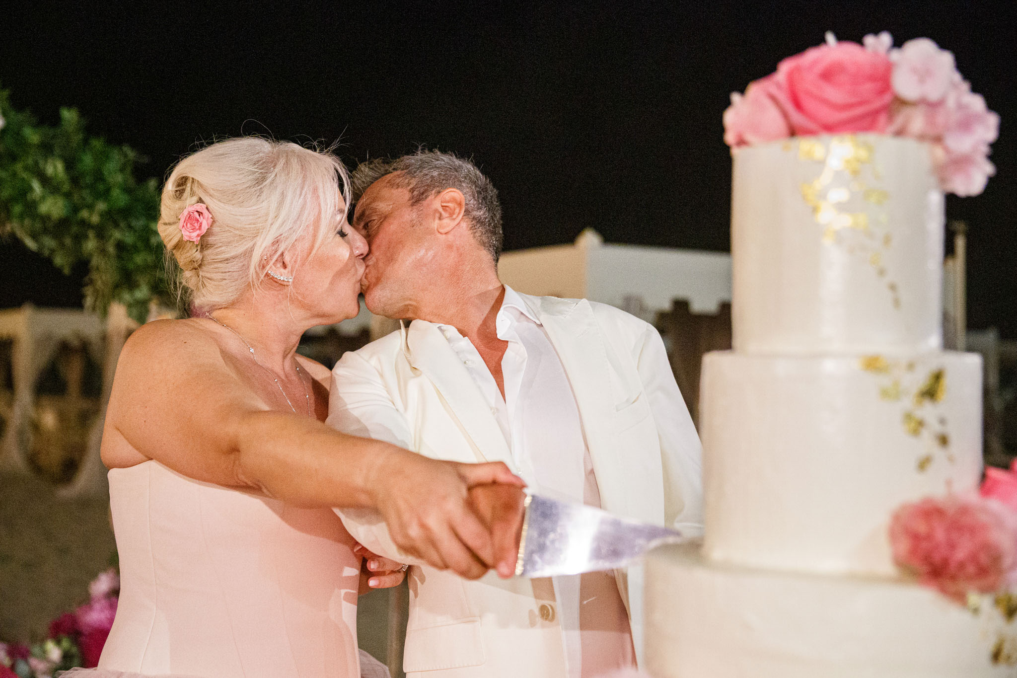 Destination Wedding Tuscany Gli sposi che tagliano la torta nuziale del loro matrimonio sulla spiaggia