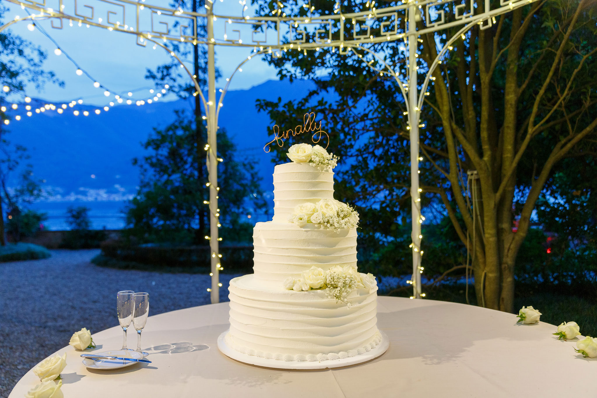 Destination Wedding Photographer Como Una torta nuziale appoggiata su un tavolo in esterno