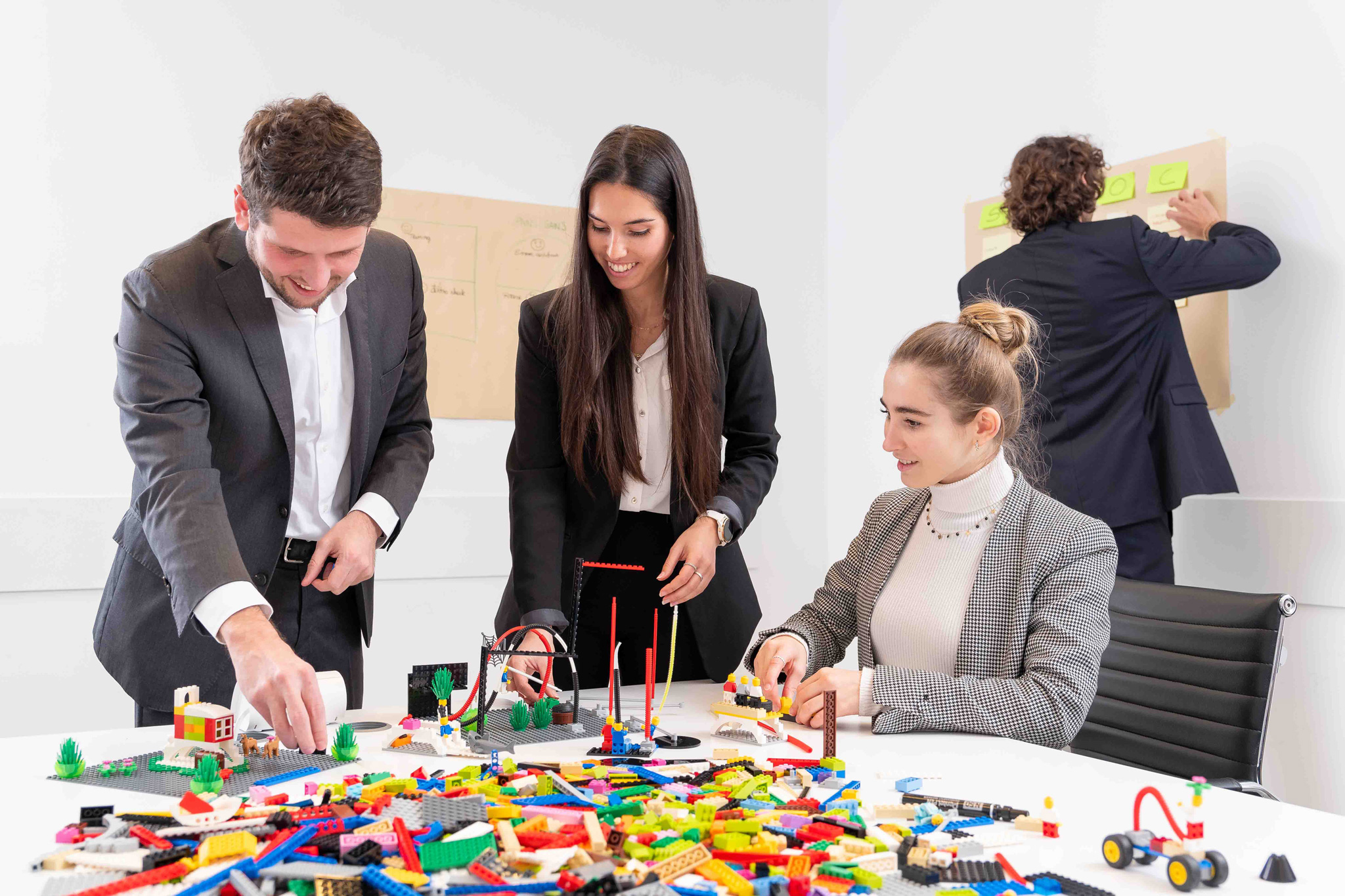 Foto business KyreTeam Colleghi che lavorano insieme con lego e lavagna